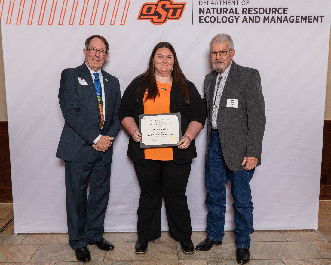 Savanah is holding her award next to Dr. Tom Kuzmic and Dr. Jim Ansley.