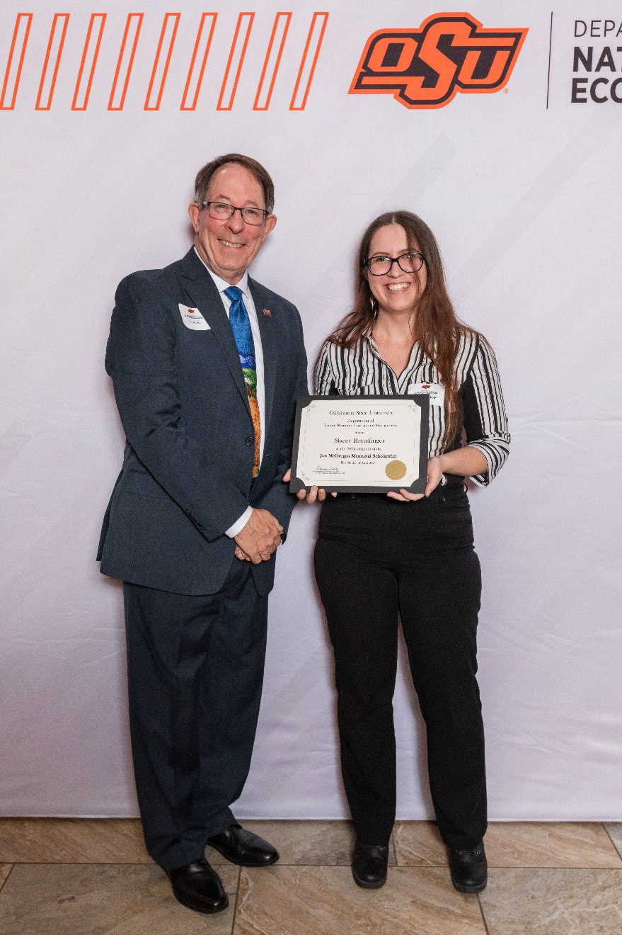 Stacey is accepting her award from Dr. Jim Ansley.