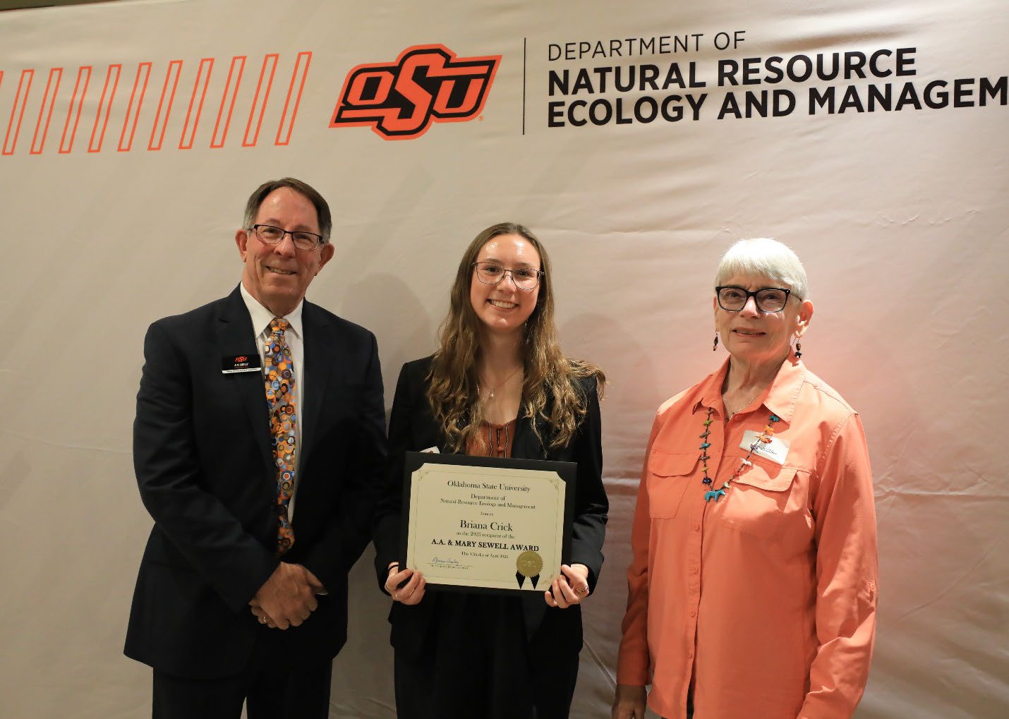 Briana Crick and her award between Luann Sewell Waters and Dr. Jim Ansley.