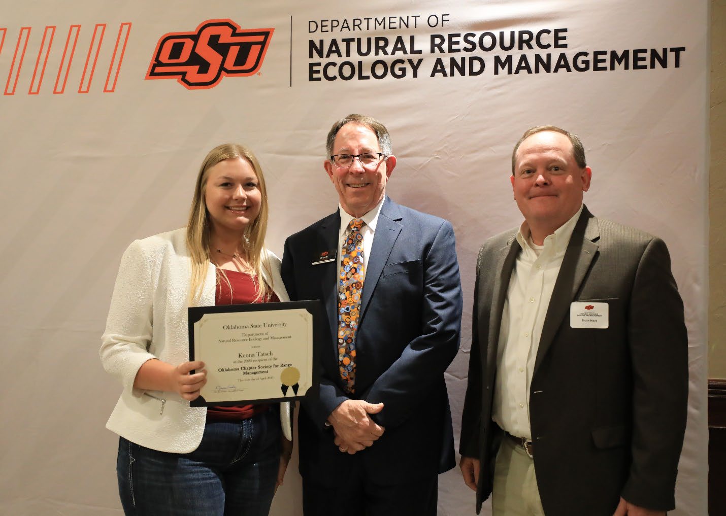 Kenna Tatsch with her plaque next to Brian and Dr. Jim Ansley.