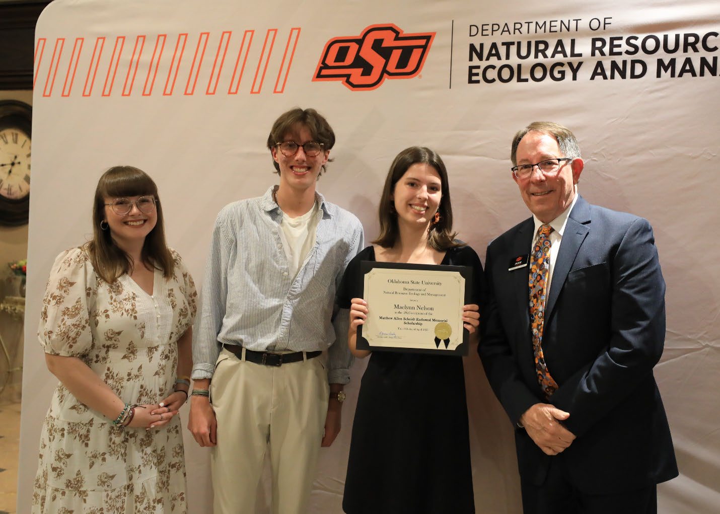 Maelynn Nelson holding her scholarship plaque next to Abigail and Alec and Dr. Jim Ansley.