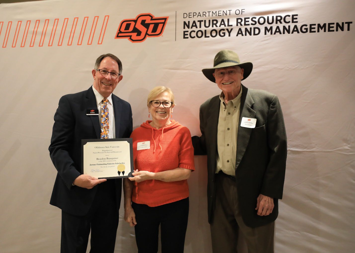 Sandy and Ron Jarman and Dr. Jim Ansley holding an award.