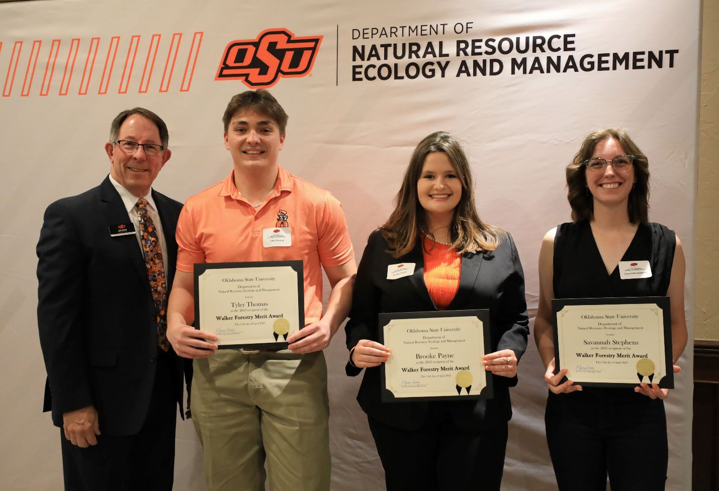 Tyler Thomas, Brooke Payne, and Savannah Stephens holding their plaque next to Dr. Jim Ansley.