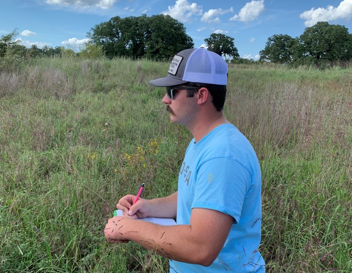 Man taking notes in the field. Man taking notes in the field.