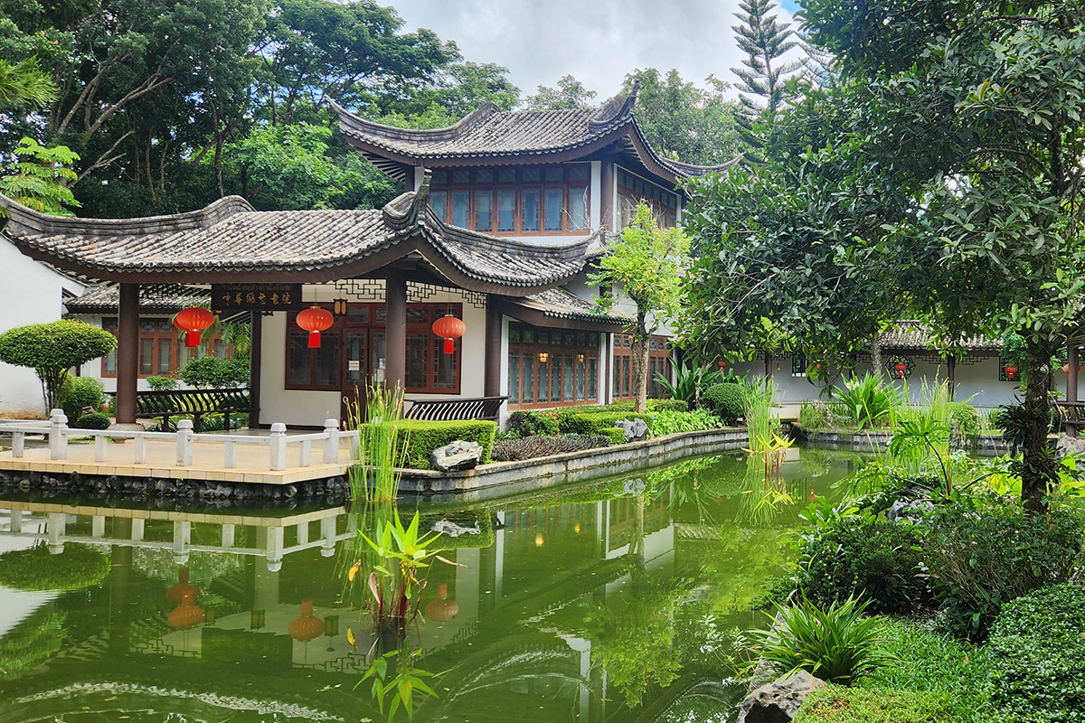 A traditional Thai building sits in a green garden area.